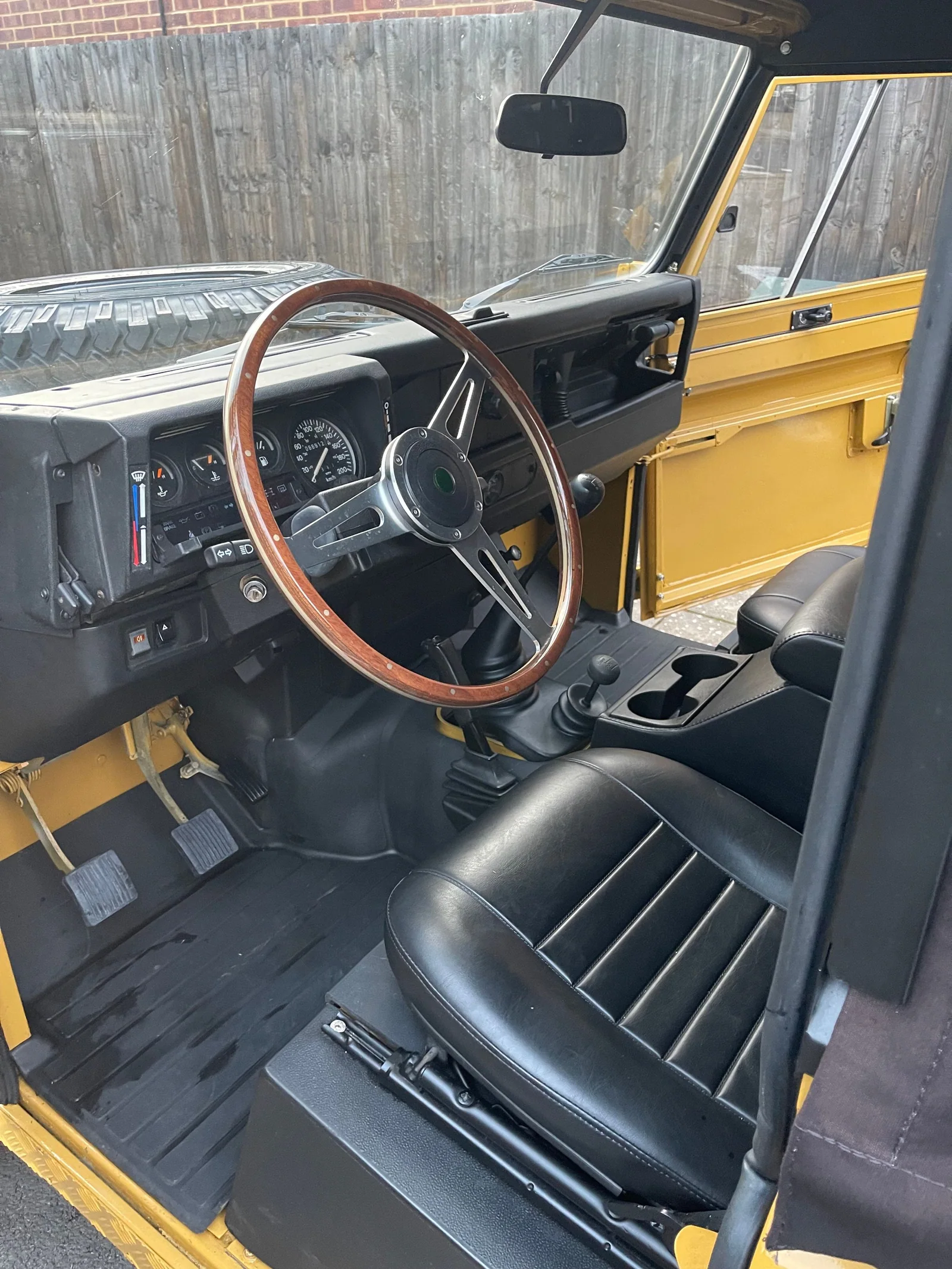 Driver seat, dashboard and wooden steering wheel in the Defender 110