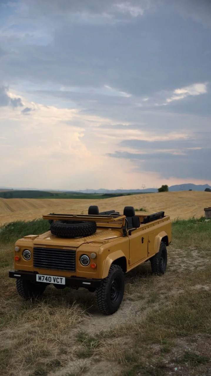 Wide front three-quarter view of the Defender 110 in a field