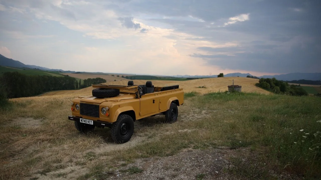 Bahama Gold 1995 Land Rover Defender 110 parked in open countryside