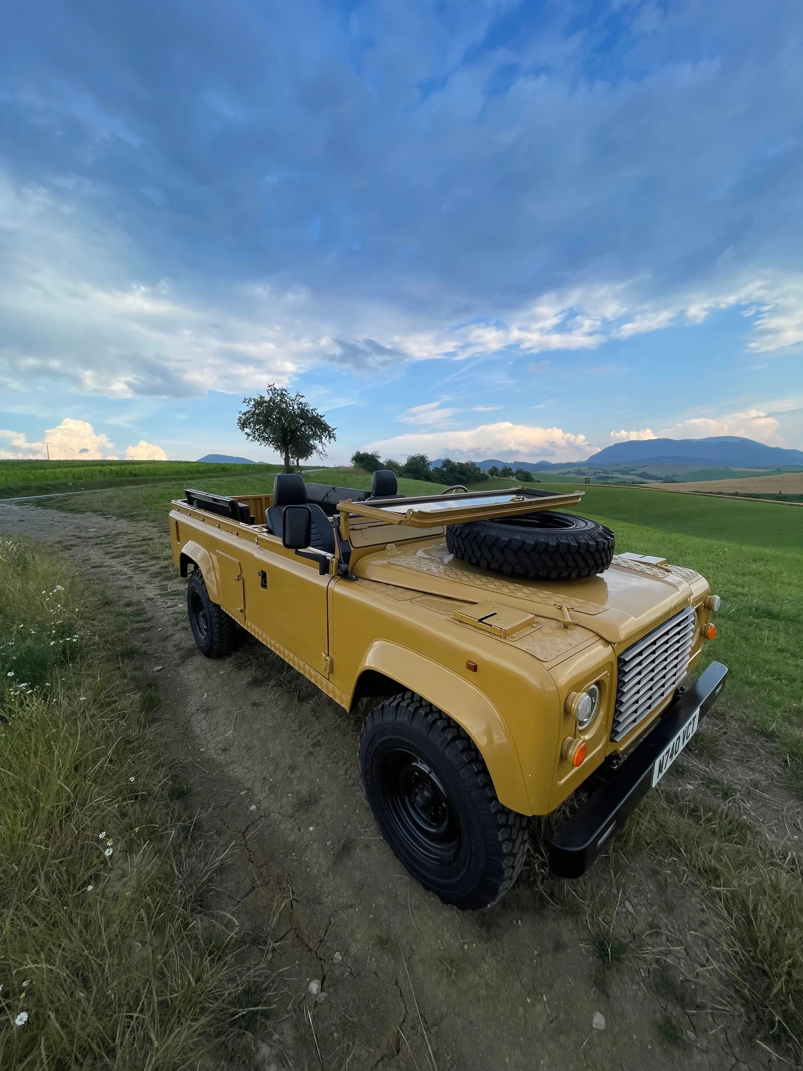Wide-angle front side view of the open-top Defender 110