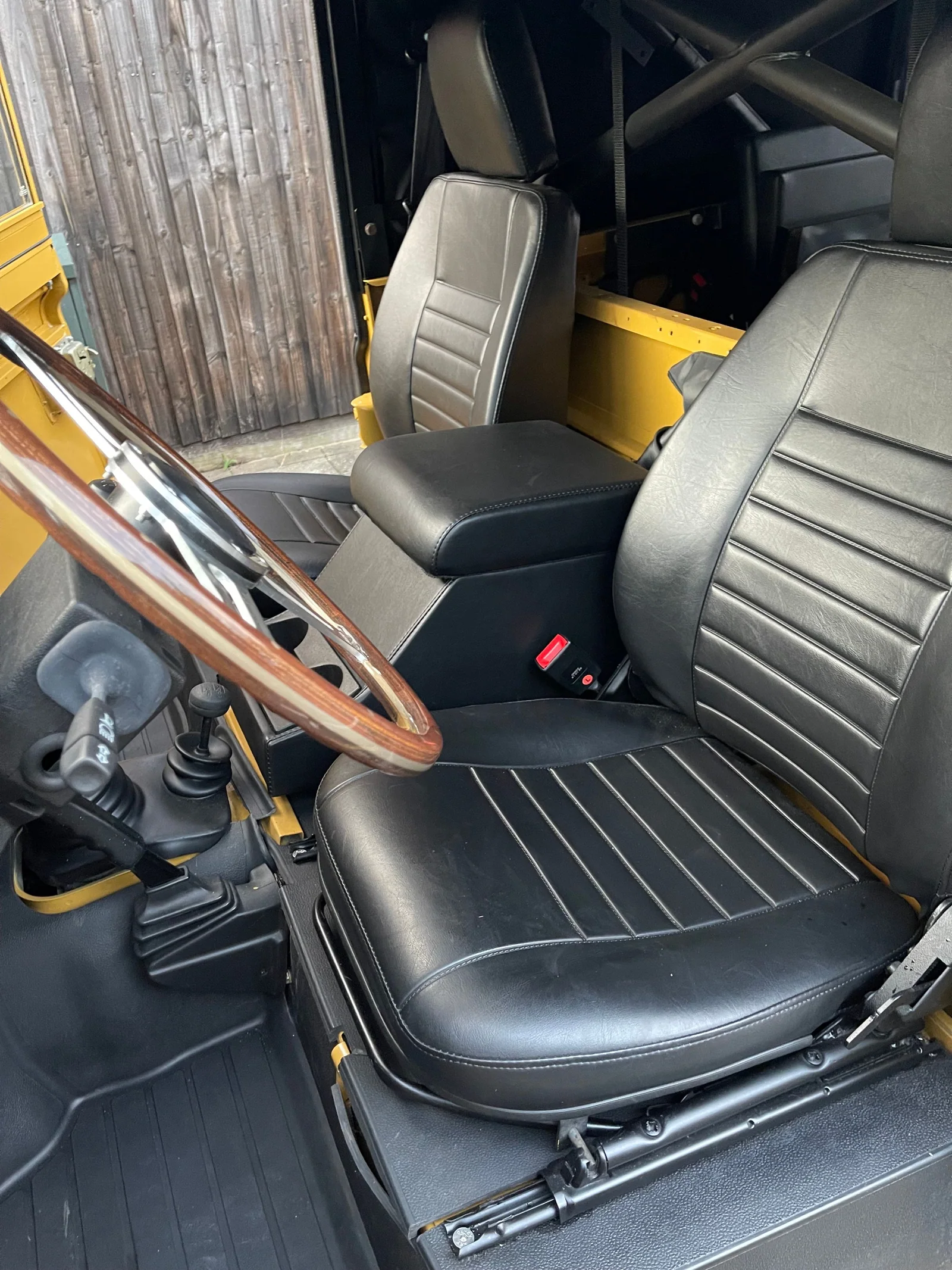 Black front seats and centre cubby box in the Defender cabin