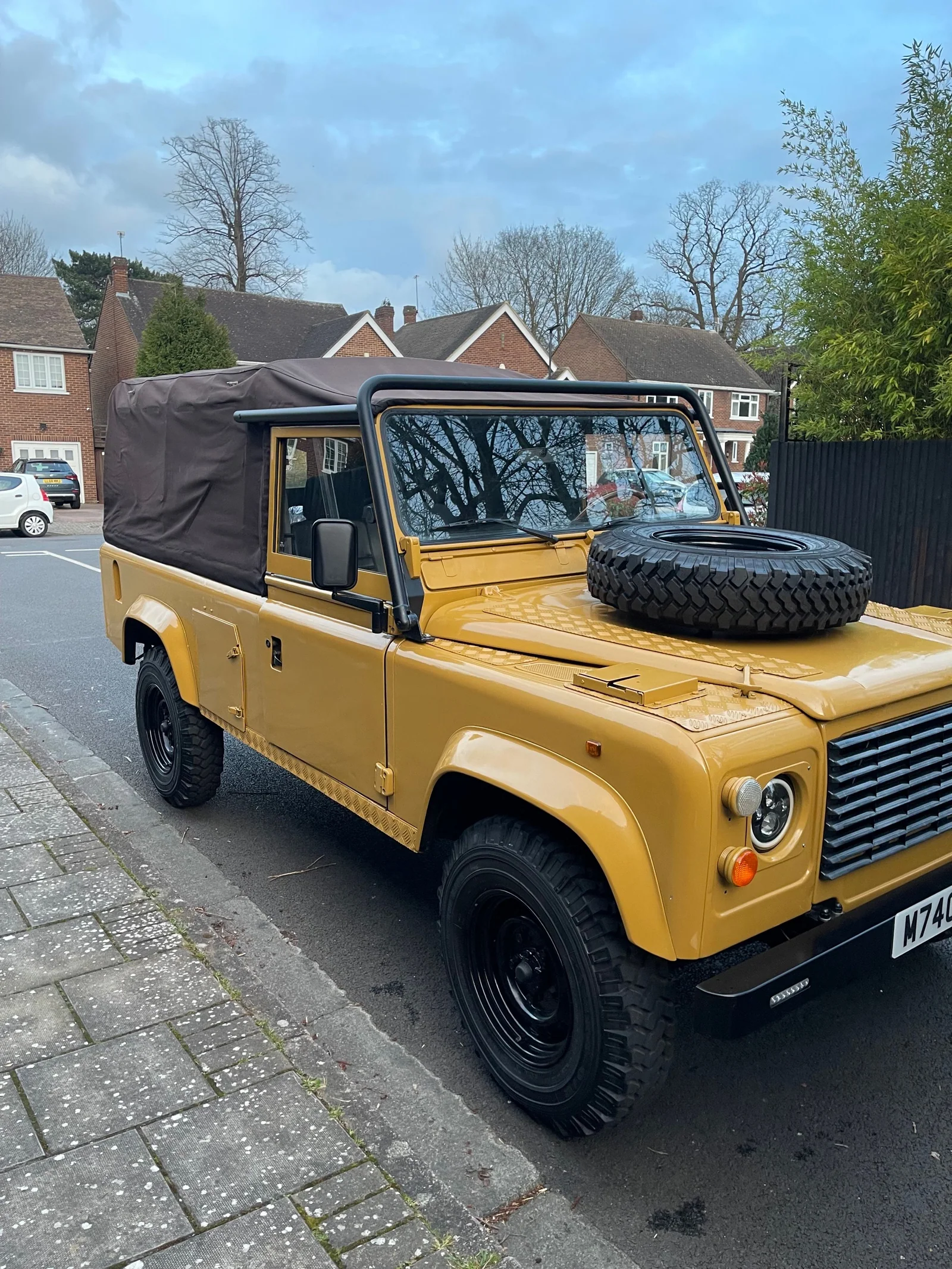 Finished Defender 110 with brown soft top viewed from the front side