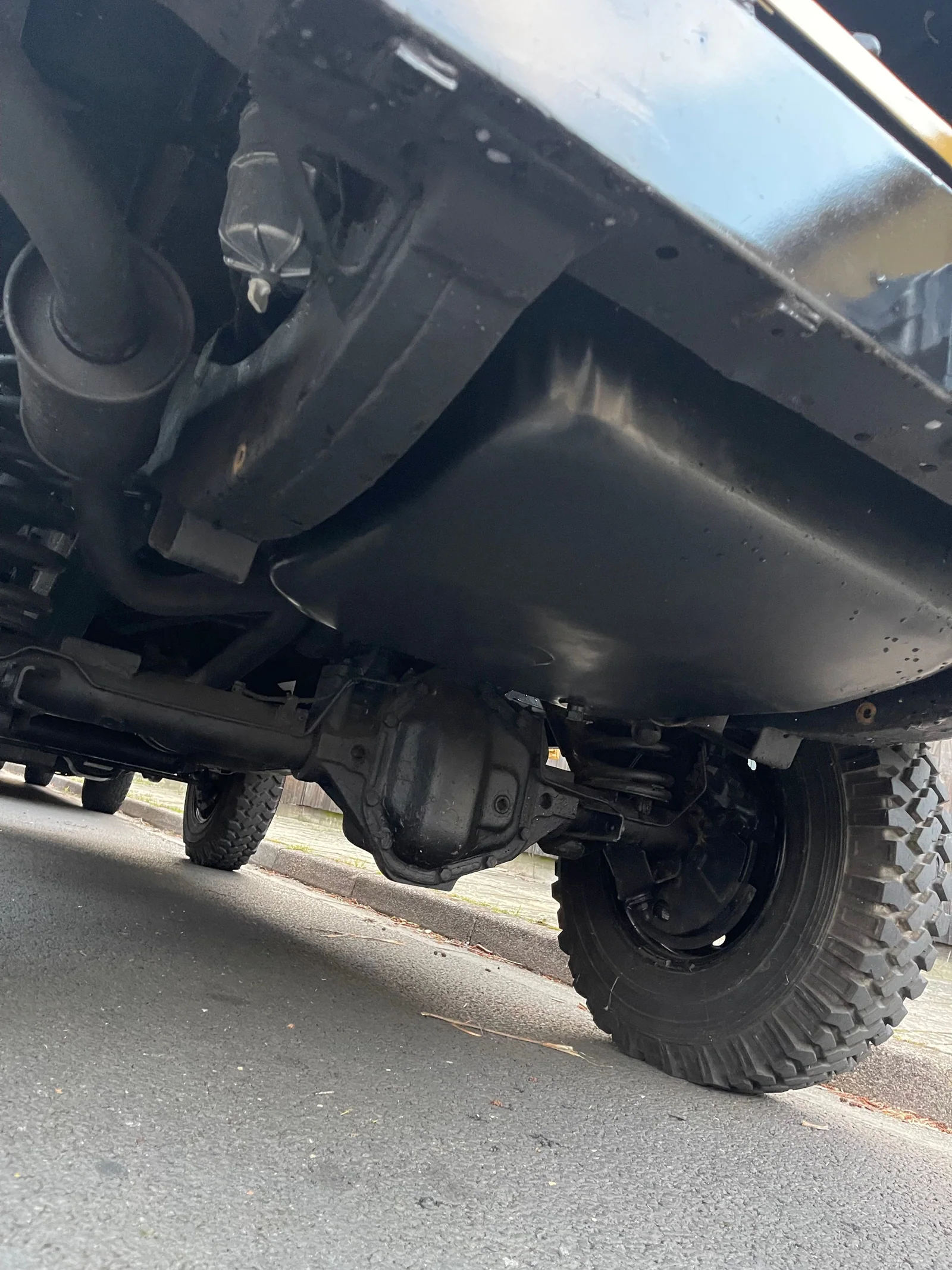 Photographed Defender underbody showing the front axle and fuel tank
